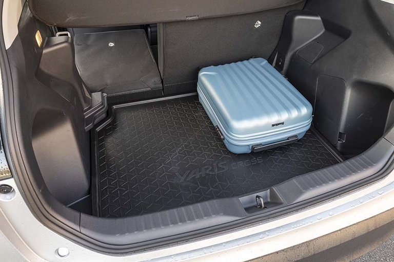 Her ses bagagerummet i en Toyota Yaris Cross med en blå kuffert
