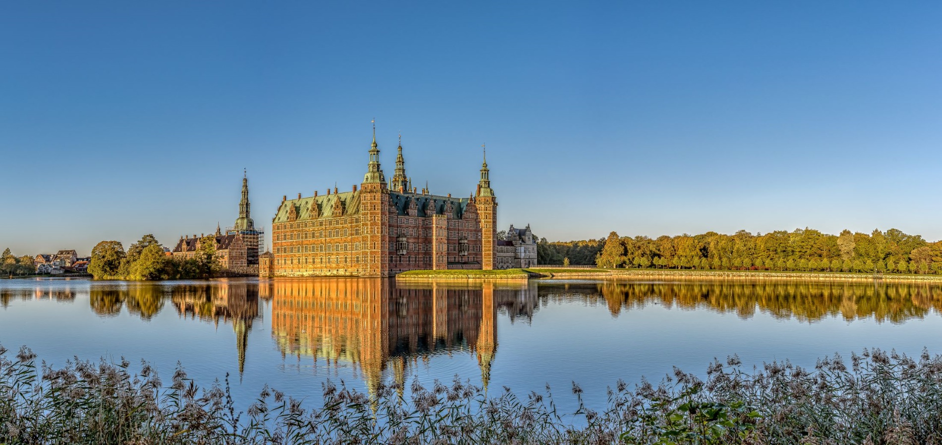 Frederiksborg slot i Hillerød på en solskinsdag med blikstille vand i søen