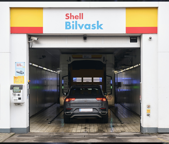En bil bliver vasket i vaskehallen hos Shell Bilvask