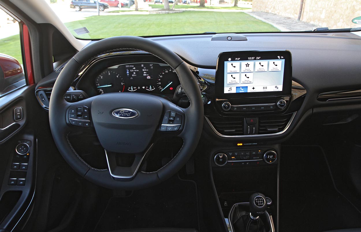Ford Fiesta har en fint indrettet førerplads med fornuftig fralægspalds. 6,5 tommer trykskærm følger med til næsten alle udgaver. Her er det 8 tommer, som koster 1.700 kr. mere. Automatisk aircondition er ekstraudstyr til alle til 4.000 kr.