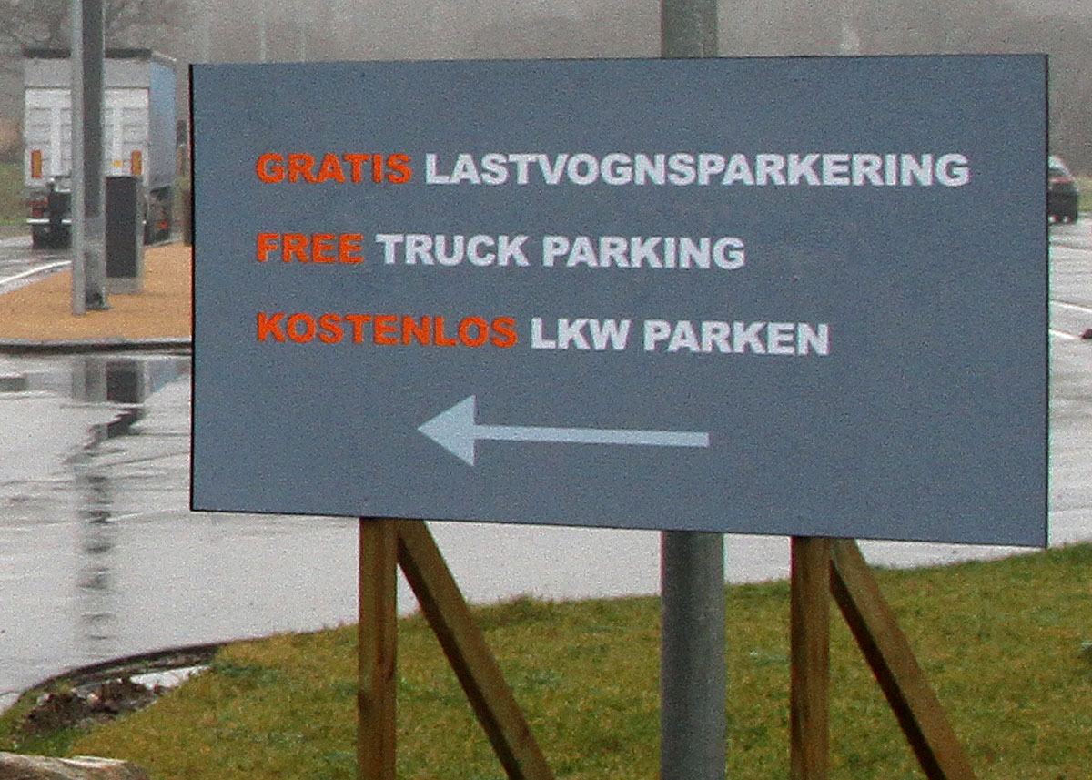 Den orange skrift er svært at læse i farten, og en del lastbiler kørte på åbningsdagen ind på personbilerens område, da chaufførerne tolkede bommen som "her skal betales".