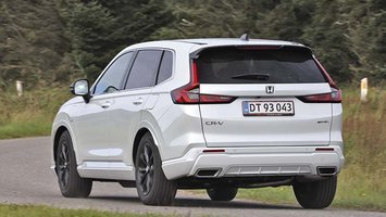 En hvid Honda CR-V set bagfra kører ind i et sving på en landevej