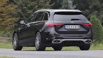 En sort Mercedes-AMG C 43 set bagfra, mens den kører på en landevej.