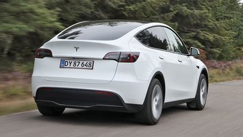 Tesla Model Y set bagfra, mens den kører på en vej