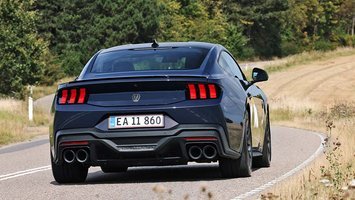 Ford Mustang set bagfra, men den kører ind i et sving på en landevej.
