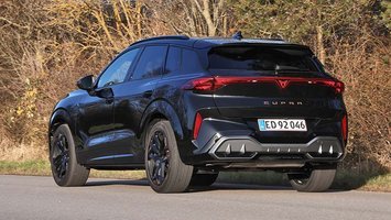 SUV'en Cupra Terramar set bagfra, mens den kører på landevej med træer i baggrunden