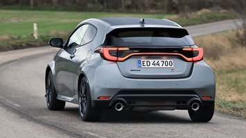 Toyota GR Yaris set bagfra, mens den kører ind i et sving på en landevej