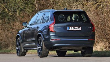 Volvo XC90 set bagfra kører på landevej med buske i baggrunden