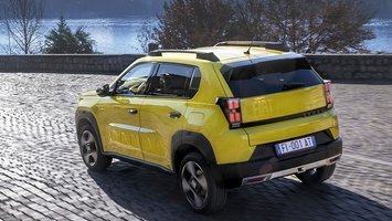 Gul Fiat Grande Panda set bagfra, mens den kører på brosten ned mod en sø
