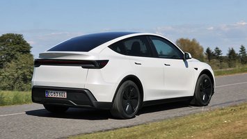 Tesla Model Y set bagfra, mens den kører på en vej