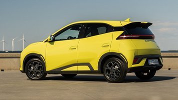 BYD Dolphin Surf set bagfra med vindmøller i baggrunden
