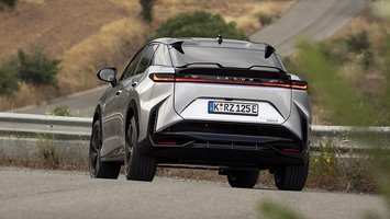 Lexus RZ set bagfra, mens den kører på en vej