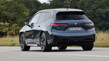BMW iX set bagfra, mens den kører på en landevej