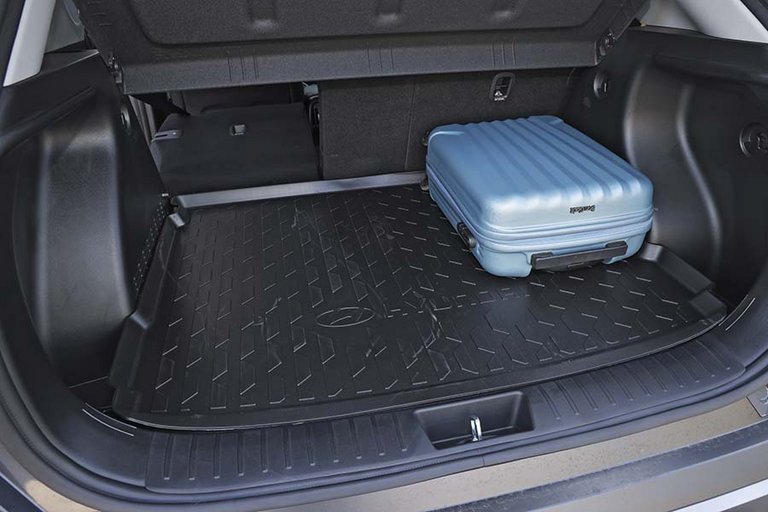 Bagagerum med blå kuffert i en Hyundai Kona.