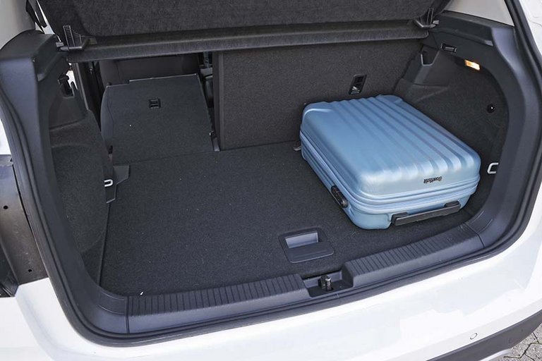 Bagagerum i en VW T-Cross med en blå kuffert i.