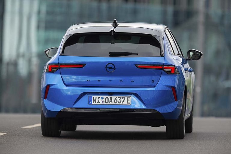 Opel Astra Electric set bagfra, mens den kører på en vej.