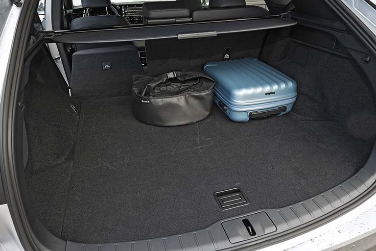 Bagagerum i en Lexus RX med blå kuffert og ladekabler