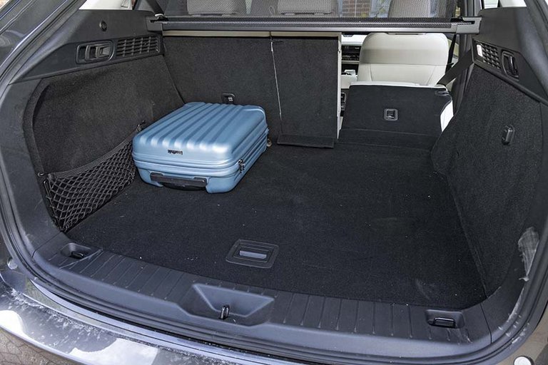 Bagagerum med en blå kuffert i en Mazda CX-60