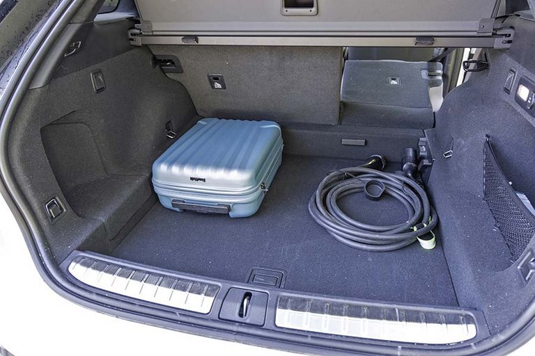 Bagagerum med kabler og blå kuffert i en Nio EL7