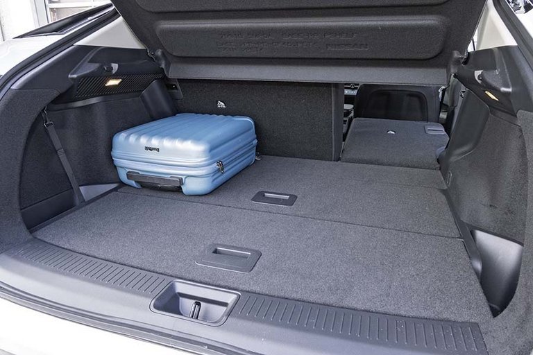 Blå kuffert i bagagerummet på en Nissan Ariya.