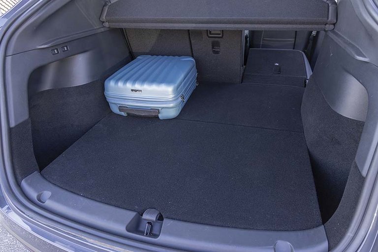 Bagagerum i en Tesla Model Y med en blå kuffert i