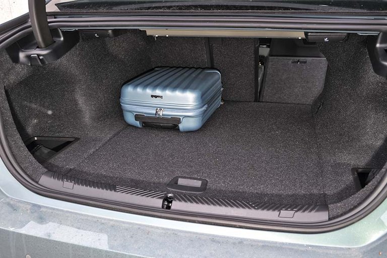 Bagagerum med blå kuffert i en BMW i5