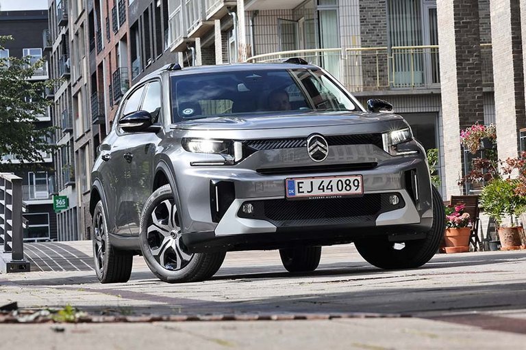 Citroën ë-C3 Aircross holder på byvej med bro i baggrunden