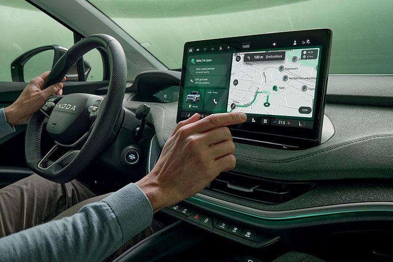 Hånd trykker på skærm i en Skoda Enyaq