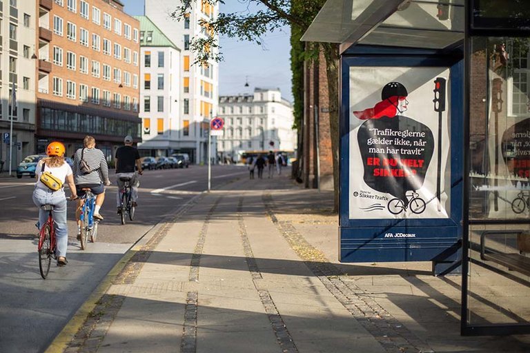 Plakat i busstoppested for bedre cykelkultur