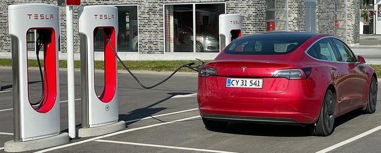 Tesla har ladestationer med gennemkørsel som her, men på de fleste holder man i parkeringsbåde, og det kan give udfordringer for nogle bilister med at få det ret korte kabel til at nå. og