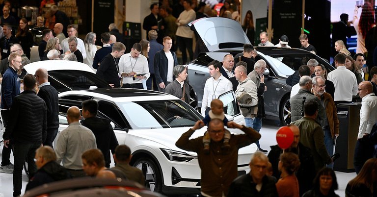 Menneskemylder ved hvid bil.