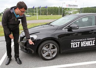 Volvo-ingeniør Mikael Thor viser, hvor nogle af bilens mange sensorer sidder. Her på hjørnet er det en ultralyd-sensor, som allerede i dag bruges til parkeringshjælp.