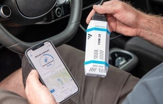 Mand holder Avilootest i hånden og tester batteriet i bilen