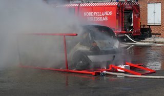 Efter fem-seks minutter med vandtåge var den voldsomme brand dæmpet. Der var lagt brandbare materialer ind i den skrottede bil for bedst muligt at simulere branden i en elbil.