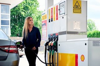 Kvinde i færd med at tanke brændstof på en Shell-station