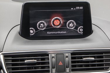 Skærmen er ret lille og er et af de områder, hvor man mærker alderen på Mazda 3. Når bilen holder stille er det en trykskærm, men under kørsel betjenes den via drejehjulet mellem forsæderne. Der er danske menuer.