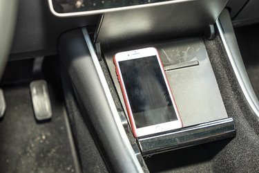 Man kan oplade en mobiltelefon via et stik i midterkonsollen. Der er stik til iPhone og andre mobiler, men Tesla har ikke f.eks. Apple CarPlay.