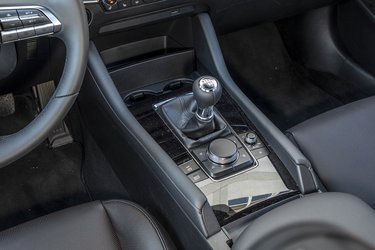 Bag gearstangen er den store drejeknap, der styrer alle funktionerne på den store skærm. To kopholdere er placeret foran gearstangen.