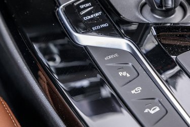 Fra eDRIVE-knappen til venstre for gearstangen kan man bestemme, om bilen skal køre på el, på benzin, eller om den selv skal finde ud af, hvad der er bedst (hybriddrift).