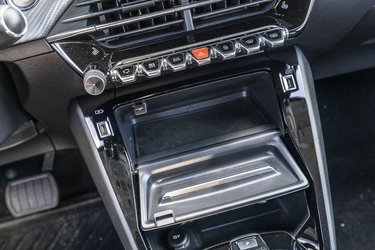 Det lille rum foran gearstangen kan åbnes med en vippeklap, der samtidig virker som hylde til mobiltelefonen. Bemærk de to typer af USB-stik.