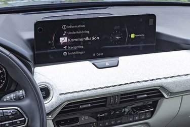 Skærmen i midten kan betjenes med en fingerspids, når man holder stille, men ikke når man kører. Så skal man bruge drejeknappen mellem forsæderne.