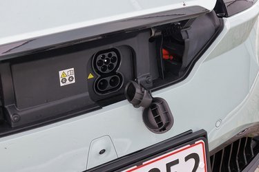 Få biler har ladestik foran, men selvom det kan være smart i forhold til hjemmeladning, så er adgangen i Omoda lidt besværlig. Låget foran stikket udløses på en knap i kabinen, og der er plastpropper hen over begge ladestik. Det er mere besværligt end i de fleste konkurrenter. 
