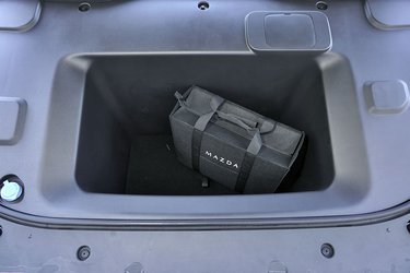 Der er en fin frunk foran. Og her er der rigeligt med plads til ladekabler og andre ting, som man ikke ønsker skal glide rundt i bagagerummet til hverdag. Der er også en fin blå markering af påfyldningen af sprinklervæske – ses nederst til venstre. 