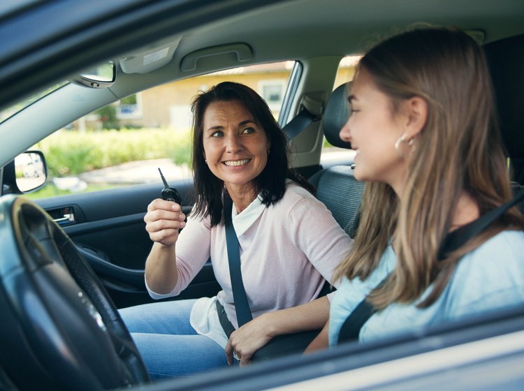To kvinder sidder i en bil, der holder stille. Den ene holder bilnøglen i sin hånd. 