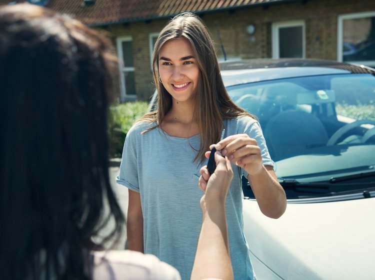 Ung kvinde får udleveret et sæt bilnøgler. 