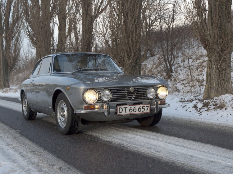 Foto af sølvfarvet Alfa Romeo i snevejr.