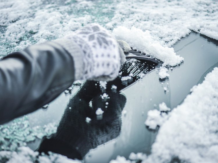 Person skraber is af forruden på bil.