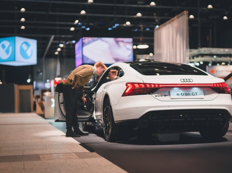 Mand kigger ind i udstillet Audi e-tron GT på elbilmessen eCarExpo.