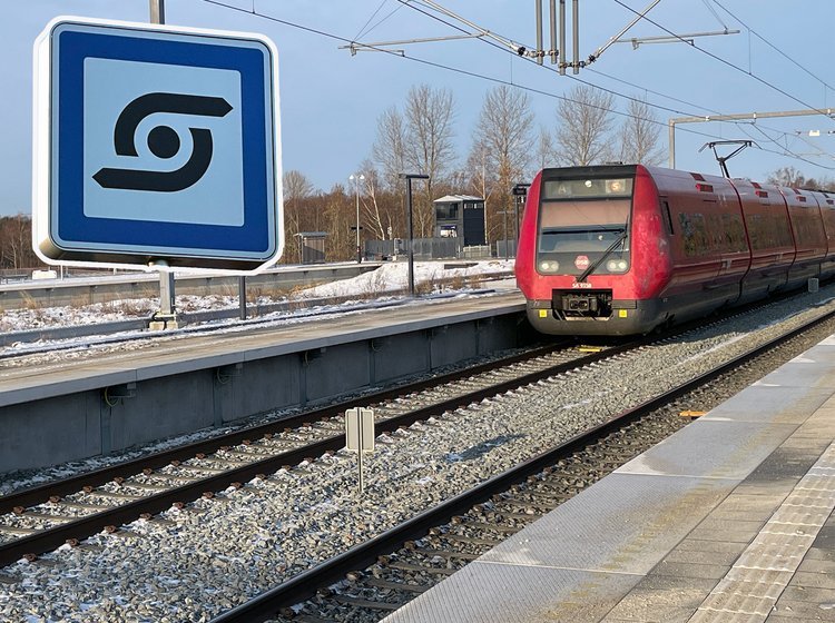 S-togs-station med rødt S-tog og symbol for station.