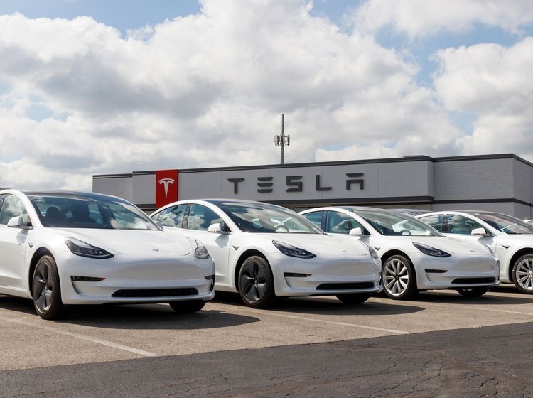 Hvide Tesla-biler foran Tesla-forhandler